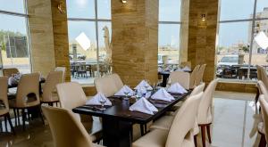塞拉莱Bristol Hotel Salalah的用餐室设有桌椅和窗户。