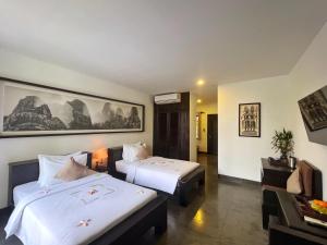 暹粒The Bliss Angkor的酒店客房,设有两张床和一张沙发