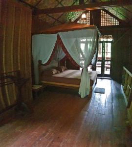 武吉拉旺Happy Ria Homestay & Guesthouse的一间卧室配有一张带蚊帐的床
