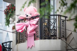 上海上海扬子饭店（每日首轮迷你吧免费）的粉红色泰迪熊坐在阳台,有粉红色的弓
