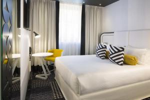 巴黎埃克塔香榭丽舍大街酒店的酒店客房,配有床和黄色椅子