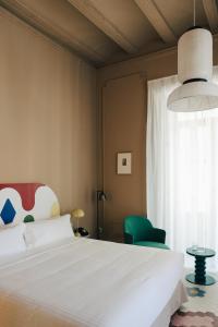 瓦伦西亚Casa Clarita的卧室配有白色的床和绿色椅子
