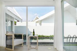 三亚三亚亚龙湾迎宾馆别墅的白色的客房设有桌子和玻璃窗