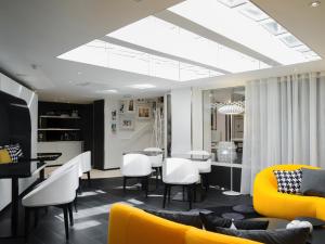 巴黎埃克塔香榭丽舍大街酒店的客厅配有黄色沙发和白色椅子