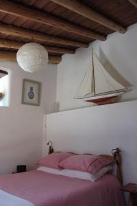 Faja Grande干草堆乡村民宿的卧室配有一张床,墙上有一条船