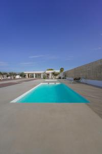 阿尔么丽亚Moott Homes Suites Villa Costacabana的一座蓝色的大型游泳池,其建筑背景为: