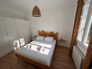 勒拉旺杜Le Rossignol 3, Aiguebelle plage, Le Lavandou的一间卧室配有一张带白色床单的床和一扇窗户。