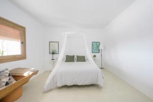 阿尔么丽亚Moott Homes Suites Villa Costacabana的白色卧室配有一张带天蓬的床