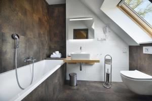 新博尔Rezidence Pihel的一间带水槽、浴缸和卫生间的浴室