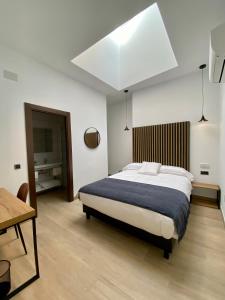 阿尔卡拉德荷那利斯伊万尼亚阿尔卡拉精品酒店的一间卧室配有一张大床和一张桌子