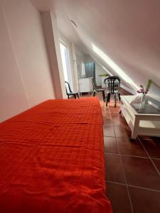 科尔多瓦ALYANA的一间卧室配有红色的床和桌椅