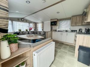 滨海克拉克顿Beautiful Caravan With Decking And Free Wifi At Highfield Grange Ref 26740wr的厨房以及带桌子的客厅。
