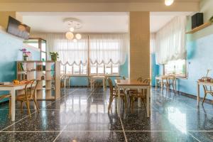 里米尼Hotel Greta B&B的一间配备有桌椅的用餐室和蓝色的墙壁
