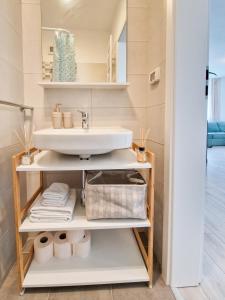 蒂米什瓦拉AZUR Apartment的浴室设有水槽和带毛巾的架子。