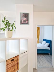 蒂米什瓦拉AZUR Apartment的一间设有一张床和一张桌子的房间,配有盆栽植物