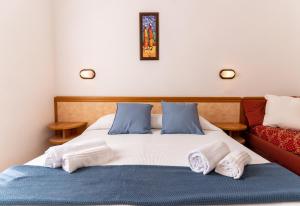 里米尼Hotel Greta B&B的一张带蓝色和白色床单的床和一张红色的沙发