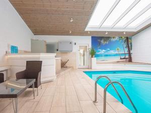 猎枪海滩10 person holiday home in Knebel的游泳池位于带桌椅的房间