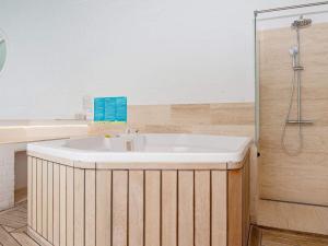 猎枪海滩10 person holiday home in Knebel的浴室配有白色浴缸和淋浴。