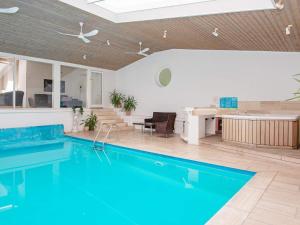 猎枪海滩10 person holiday home in Knebel的一个带厨房和桌子的房子内的游泳池