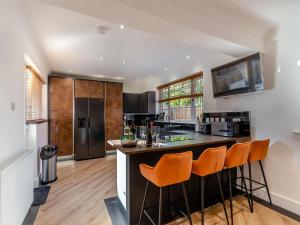 SewerbyLindengarth的厨房设有1个带橙色酒吧凳的岛屿