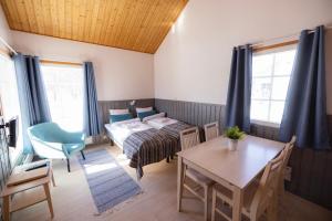 奥卢纳里卡瑞乡村度假屋假日公园的配有一张床和一张桌子及椅子的房间
