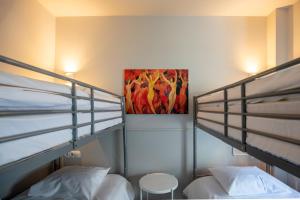 卢森堡布里斯托酒店的卧室配有两张双层床,墙上挂有绘画作品