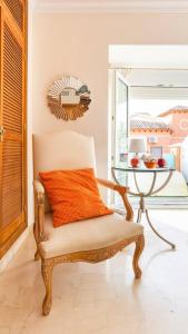 多列毛利诺斯Z&Olé的配有橙色枕头和桌子的椅子