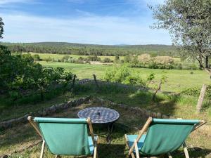 Fox-AmphouxPierre de Lune的两把椅子和一张桌子,享有田野的景色