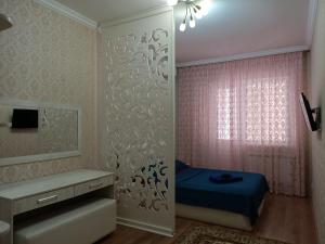 奇姆肯特Апартаменты в жилом комплексе БИИК的一间卧室配有蓝色的床和镜子