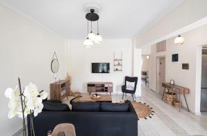 ZográfosIrena House by RentalsPro - Dionisiou Halkidiki的客厅配有黑色沙发和桌子