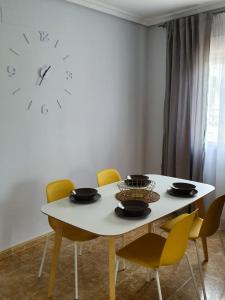 卡布罗伊格Playamarina 1 Reception的餐桌、椅子和墙上的时钟