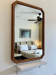 彭亨Country Side Modern Concept Cottage的墙上的镜子,房间里的床