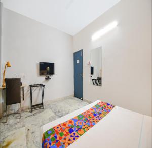 加尔各答FabHotel Silverkey Kalighat的一间卧室配有一张带彩色毯子的床