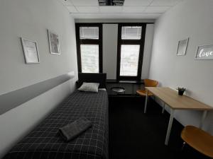 华沙Aleja "Solidarności"的客房设有床、桌子和窗户。