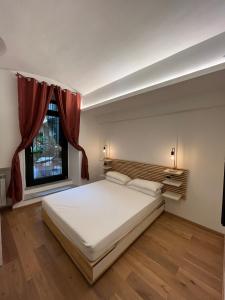 都灵Suite The Brick的卧室设有一张白色大床和一扇窗户。