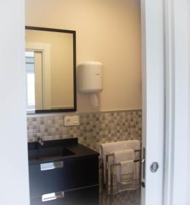 阿斯托加Astorga suites的一间带水槽和镜子的浴室