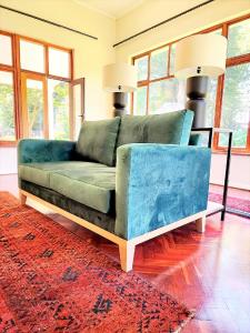 诺丁汉路Hydrangea Guest House的客厅里一张蓝色的沙发,上面有红色地毯