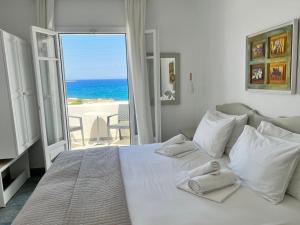 纳乌萨瓦瓦诺斯公寓的卧室设有白色床,享有海景