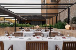 波连斯萨桑布鲁尔水疗酒店 的餐厅配有白色桌椅和酒杯