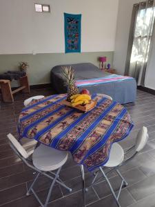 圣佩德罗·德·阿塔卡马Cabañas Rica-Rica Lodge的一张桌子,上面放着香蕉和 ⁇ 萝,放在房间里
