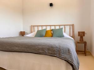 Es ArenalsArenas del Mar Formentera的一间卧室配有一张带色彩缤纷枕头的大床