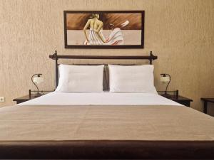 梅萨雷亚维拉丹内齐斯的一间卧室配有一张带两盏灯的床,墙上挂着一张照片