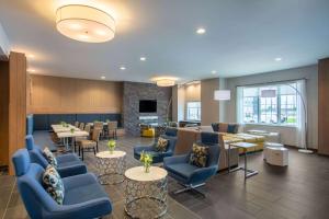 利伯蒂Microtel Inn & Suites by Wyndham Liberty NE Kansas City Area的一间设有蓝色椅子和桌子的等候室