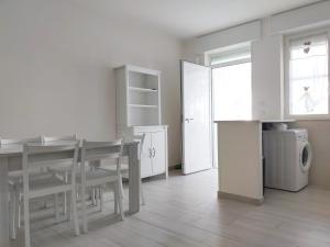 贝瓦尼亚圣彼得A due passi sul mare的白色的厨房配有桌子和洗衣机。