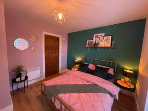 伊普斯威奇Waterfront 2 bed apartment with views over Ipswich的一间卧室设有粉红色的床和绿色的墙壁