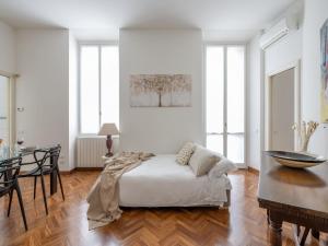 米兰The Best Rent - Gorgeous two-bedroom apartment in Porta Nuova district的白色卧室配有床和桌子