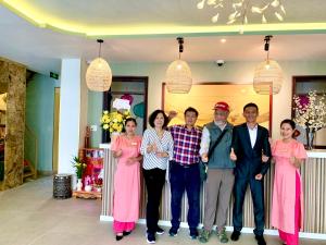 会安DE VIVRE HOI AN - Aman Boutique Hotel的一群人在一个房间里摆着一张照片