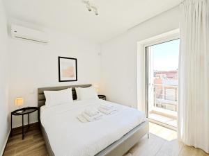 雅典Nemeseos Apartments by Verde的白色的卧室设有一张白色大床和一个窗户。