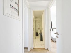 雅典Nemeseos Apartments by Verde的走廊通往带卫生间的浴室