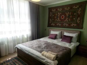 舍基Guest House Ruh Achari的一间卧室配有一张带紫色枕头的大床